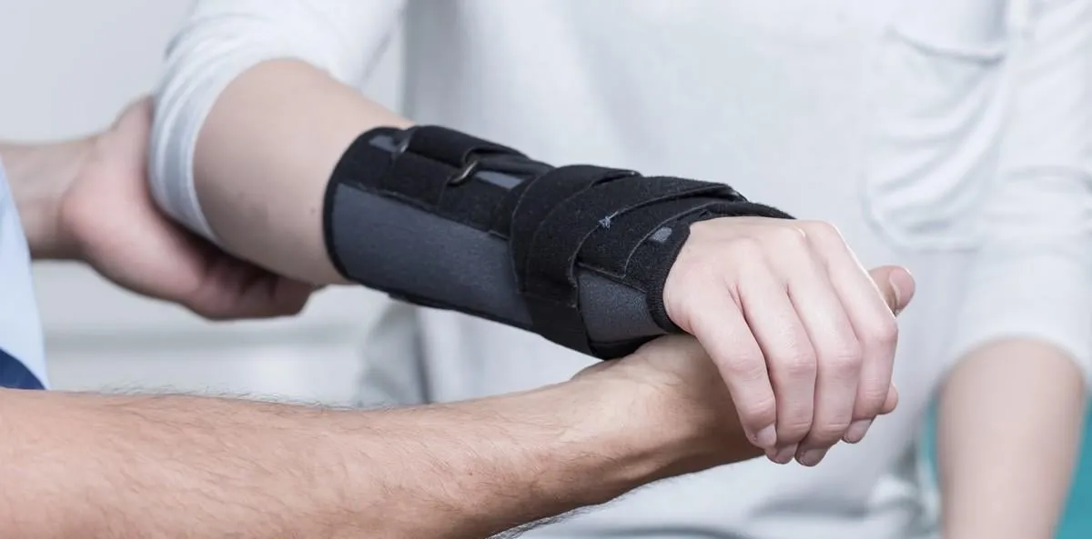 woman with dislocated wrist in stabilizer is consulting doctor