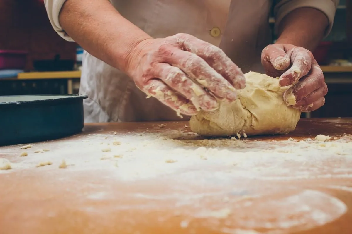 closeup photo of baker making yeast dough for bread retro styled imagery