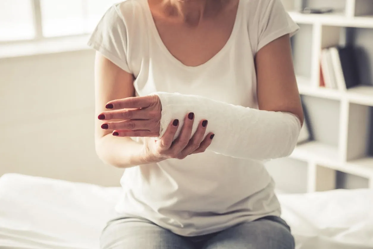 cropped image of beautiful mature woman with her arm in gypsum sitting at the traumatologist