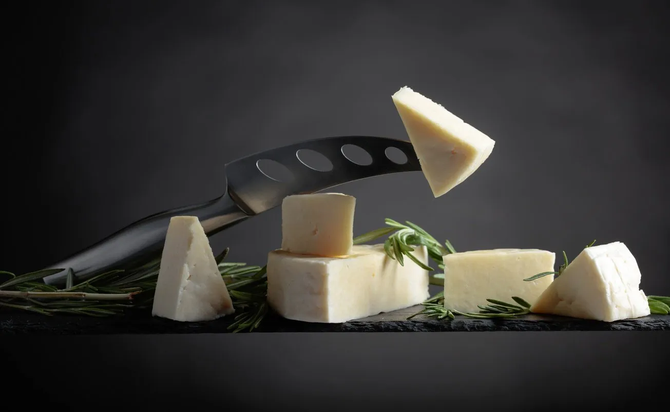 cheese with rosemary and knife on a black background