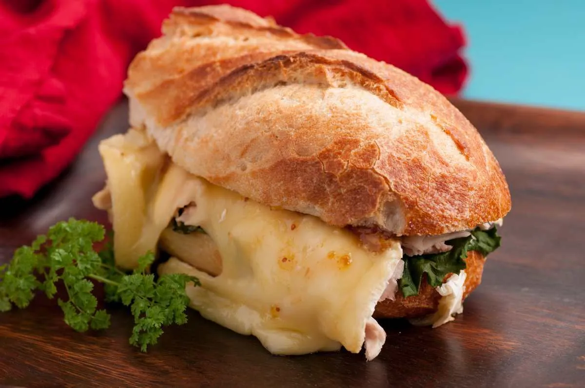 brie melted on chicken on a baguette bread roll