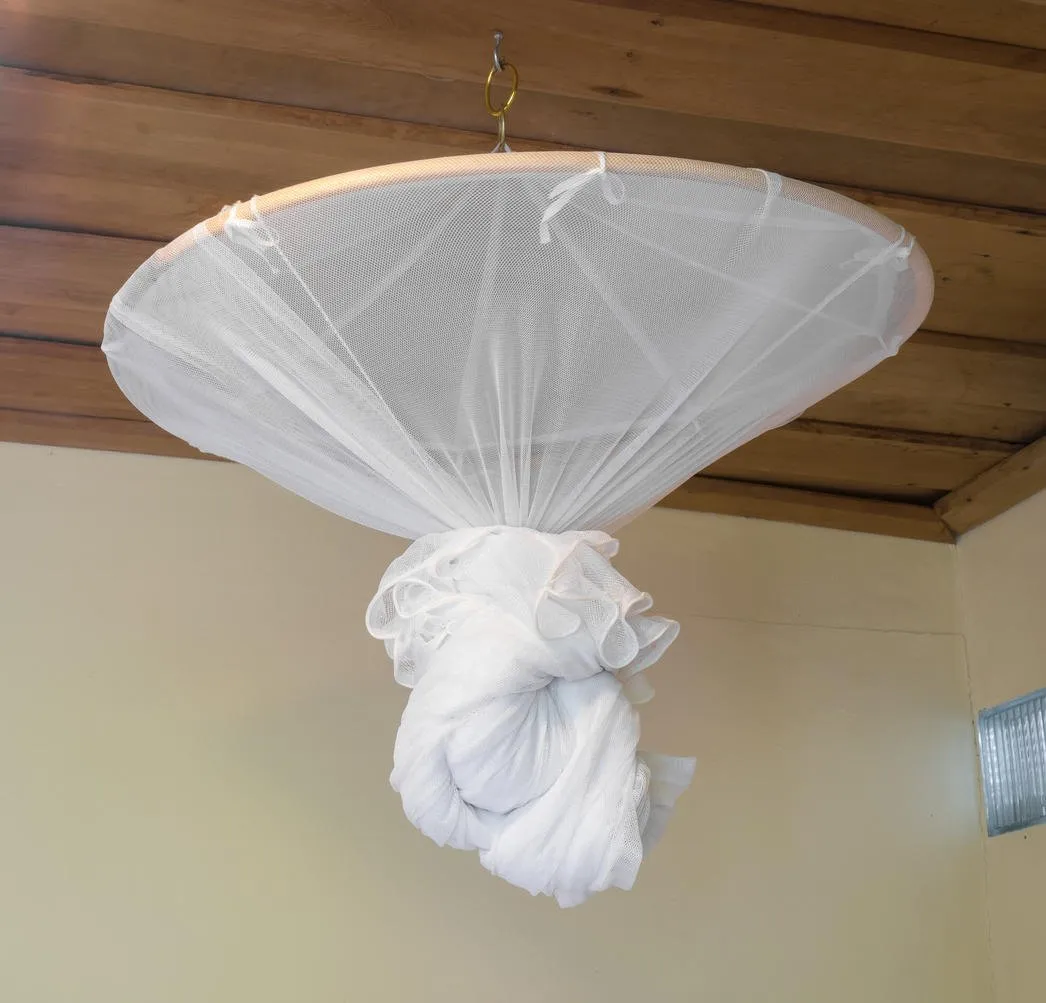 plier une moustiquaire sur un lit dans la chambre