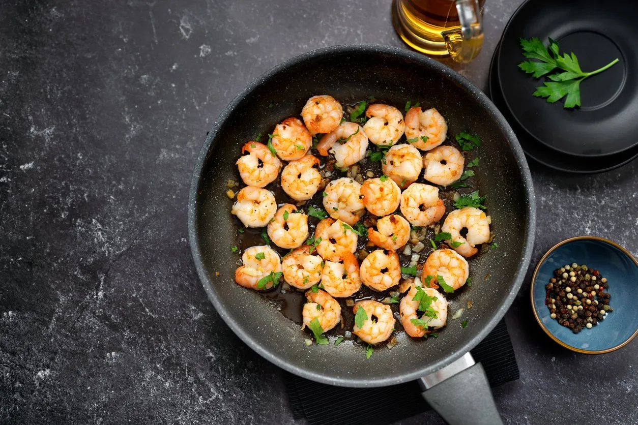 top view of fried prawns in a pan on black background