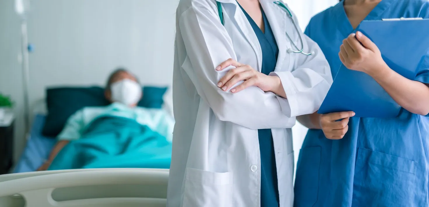 doctor and nurse medical team with patient in background
