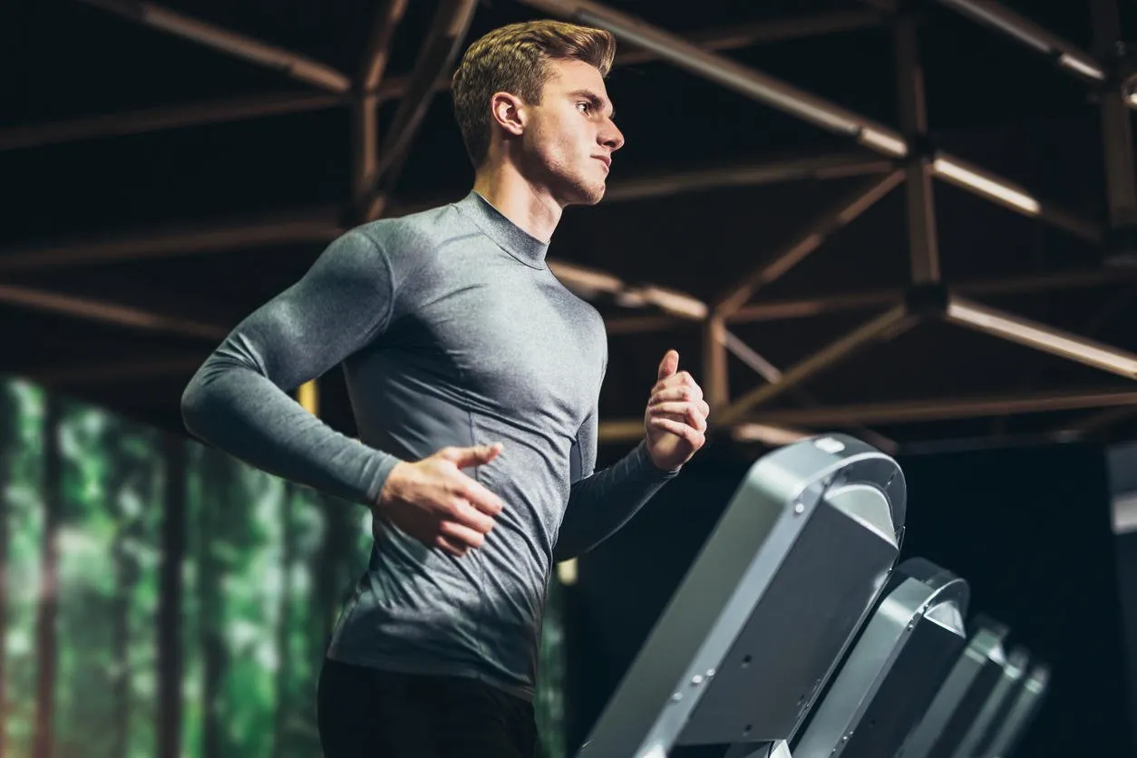 man running in a gym on a treadmill concept for exercising, fitness and healthy lifestyle
