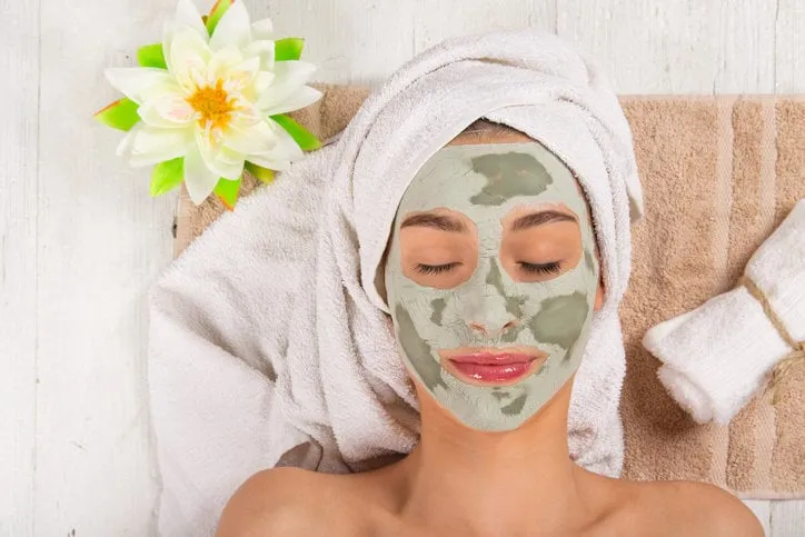 young healthy woman in spa making treatments and face mask