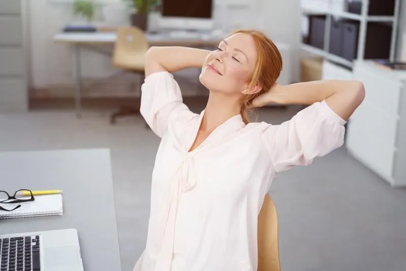 femme au bureau se penchant en arrière détendue