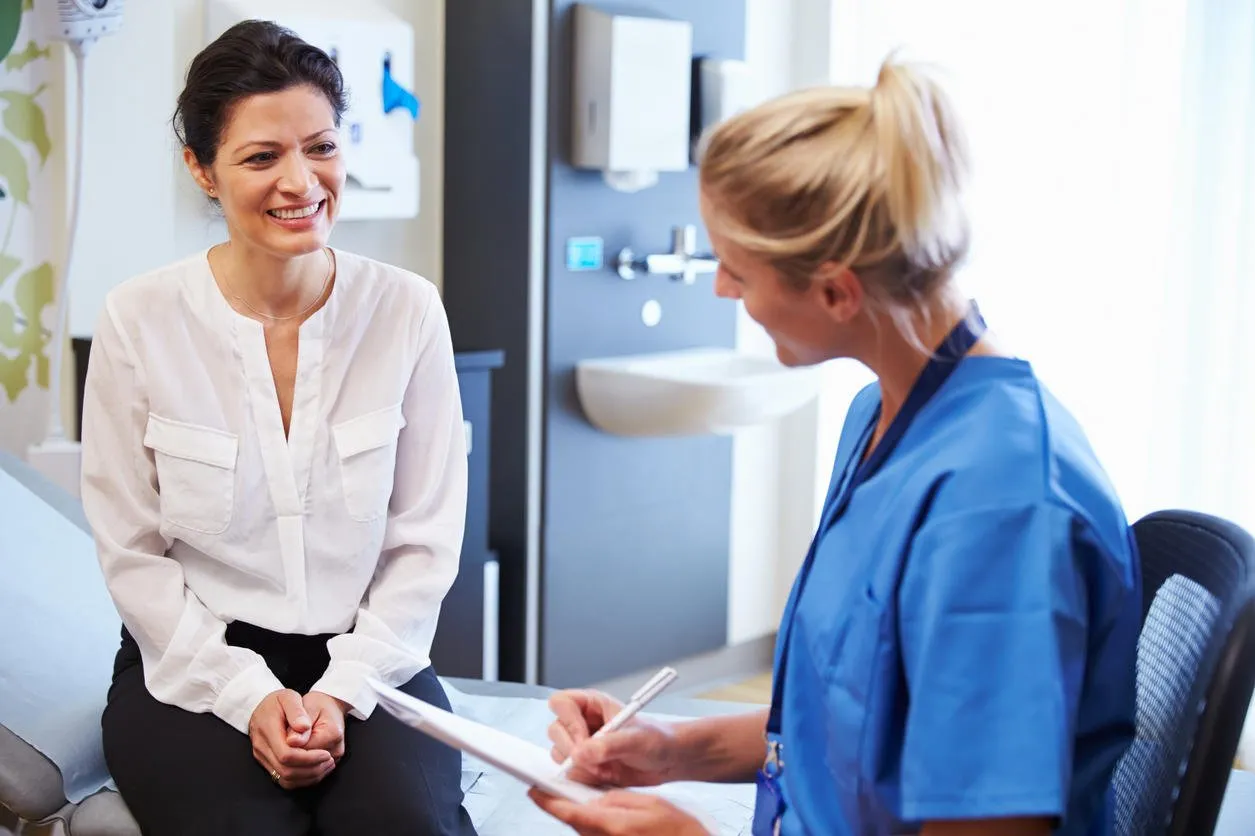 female patient and doctor have consultation in hospital room