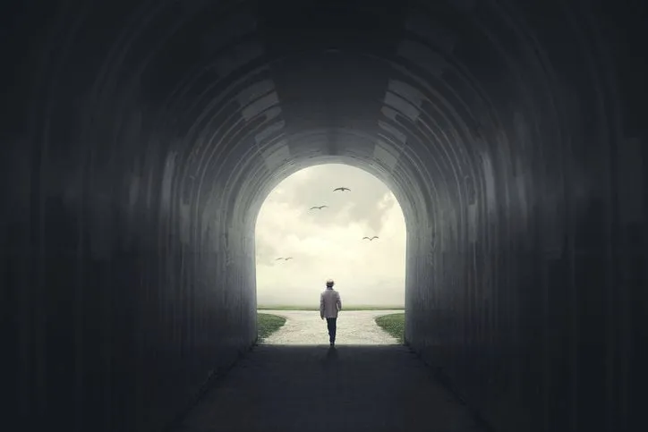 man getting out from a dark tunnel