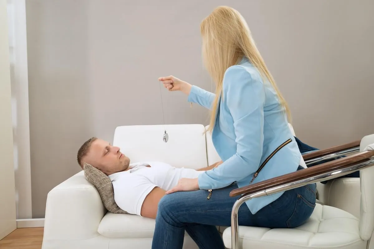 female psychiatrist hypnotizing patient lying on couch