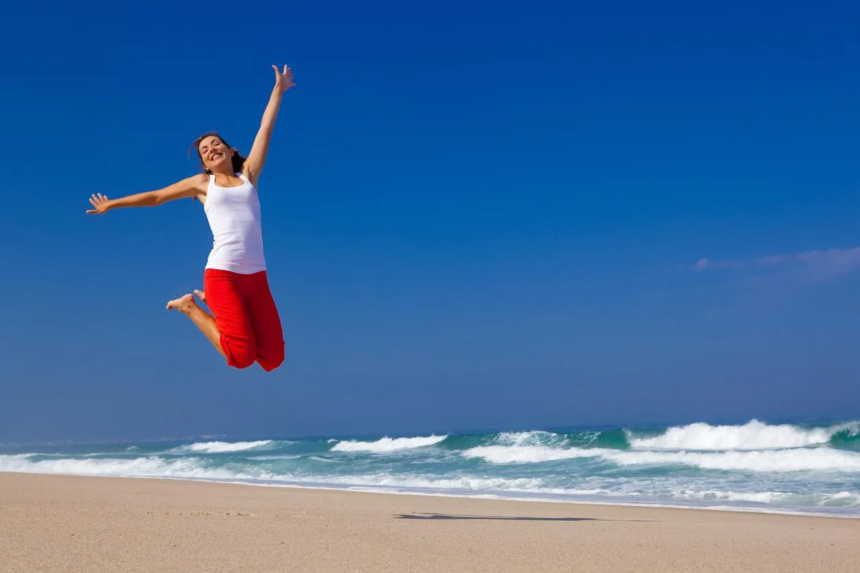 beautiful young woman jumping on the beach