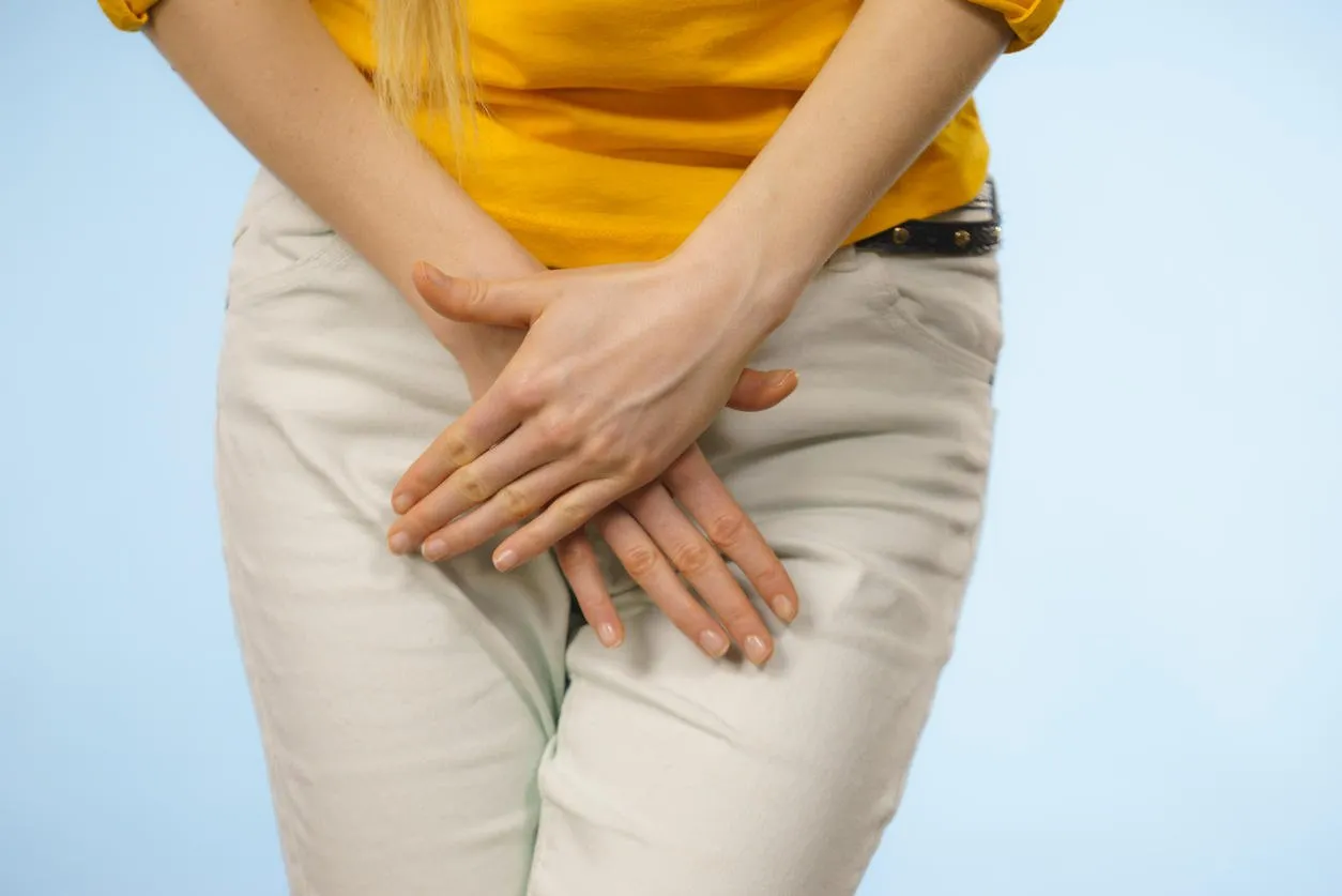 closeup young sick woman with hands holding pressing her crotch lower abdomen medical or gynecological problems, healthcare concept