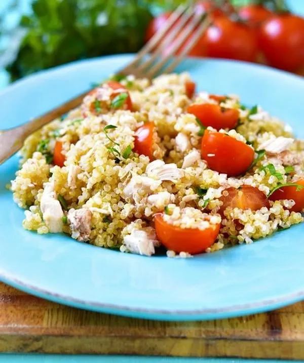 salade de quinoa aux tomates cerises et poulet sur un fond bleu