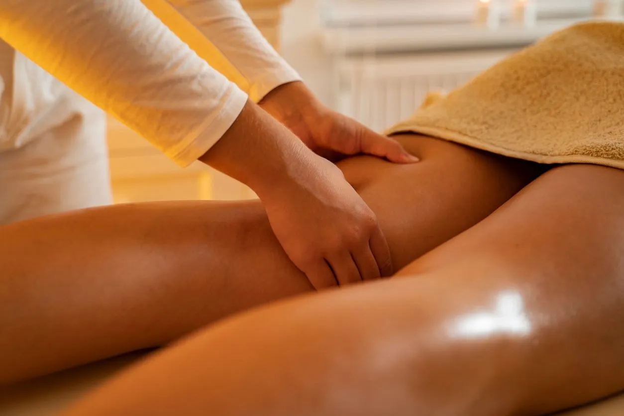 closeup masseuse massaging clients thighs , leg massage