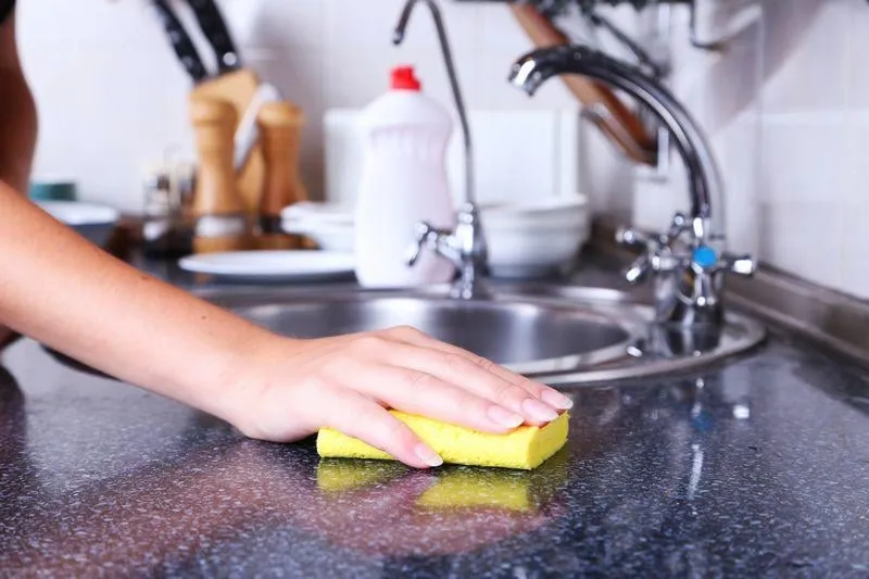 male hand in gloves with sponge cleaning bathroom