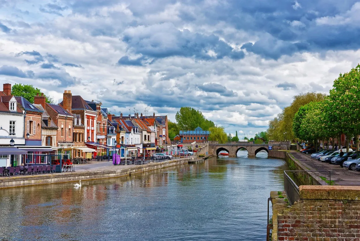 amiens, france - may 9, 2012  quay of belu with traditional houses and somme river in amiens, picardy, france people on the background