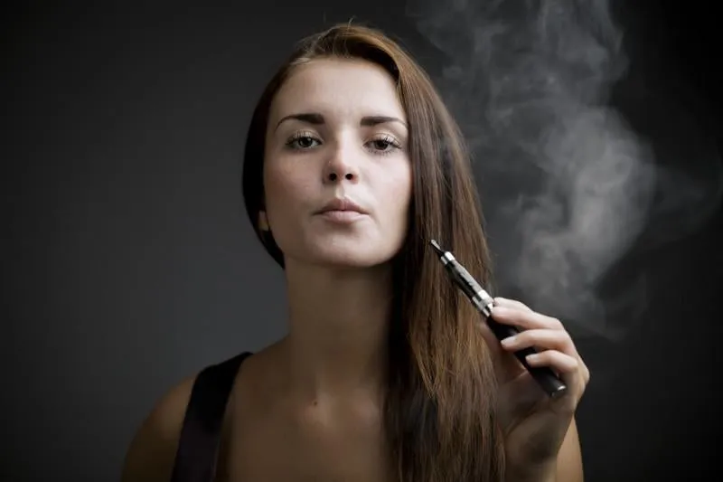 femme élégante fumer e-cigarette avec portrait de fumée