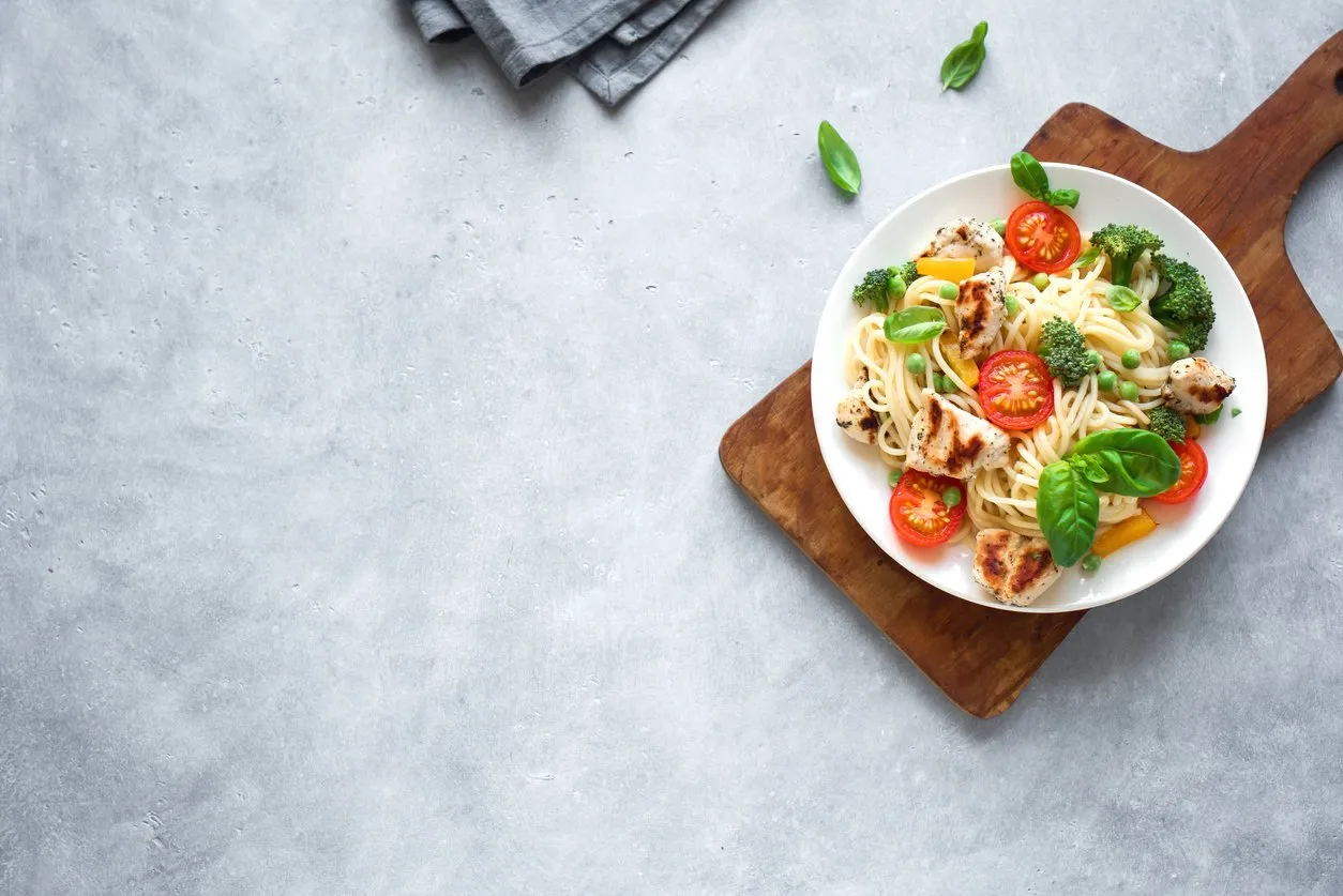 chicken and vegetables pasta spaghetti pasta with grilled chicken meat, vegetables and basil, top view, copy space seasonal pasta primavera recipe