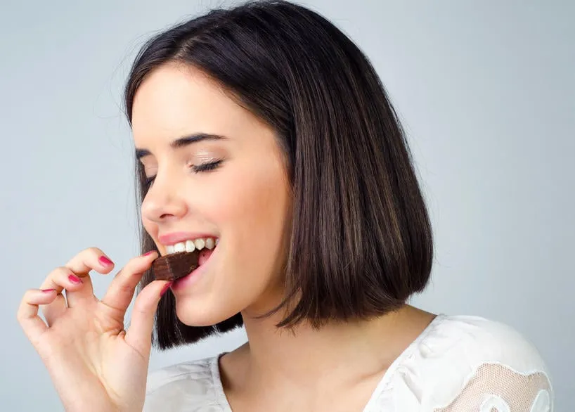 portrait de la belle fille, manger des biscuits au chocolat isolés sur fond gris