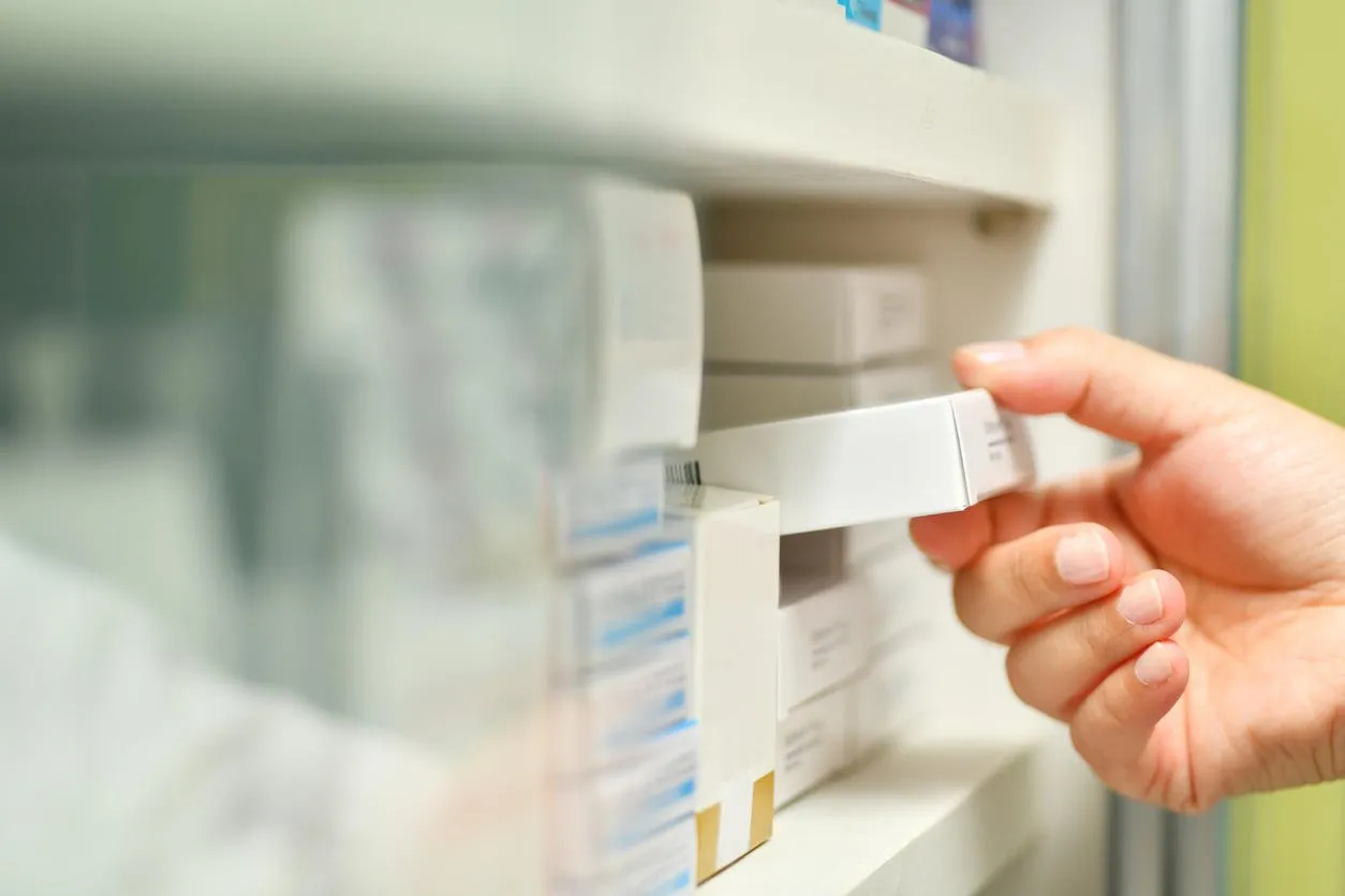closeup pharmacist hand holding medicine box in pharmacy drugstore