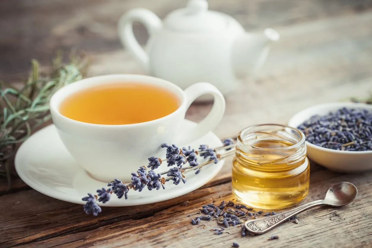 healthy tea cup, jar of honey, dry lavender flowers and teapot on background selective focus retro styled