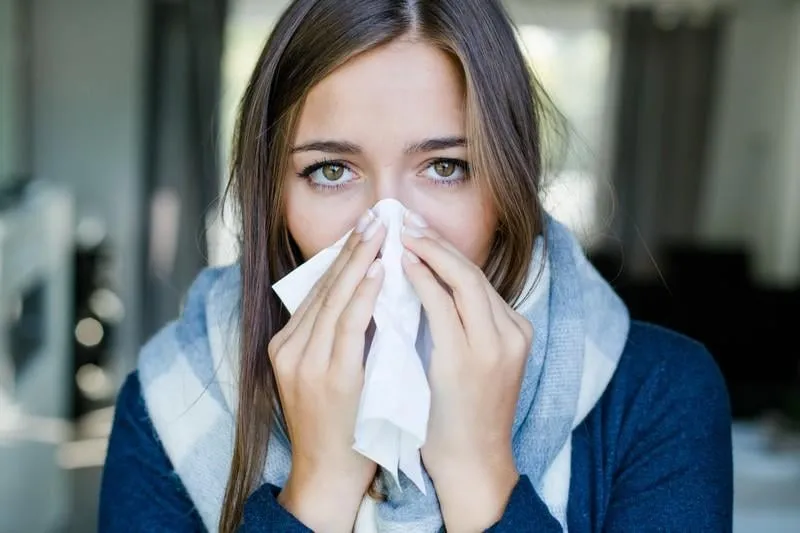 frau putzt sich ihre nase