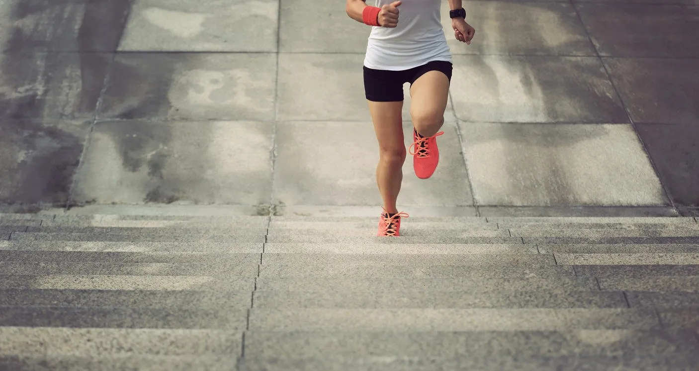 femme de sport jeune qui court à l'étage sur les escaliers de la ville