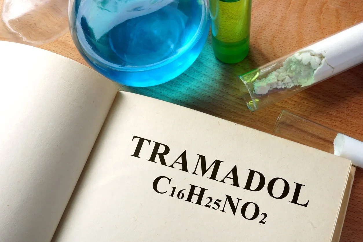 book with tramadol and test tubes on a table