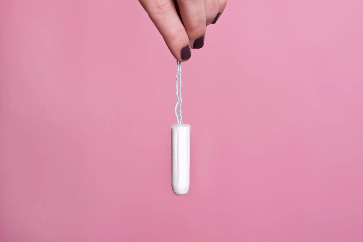 woman's hand holding a clean cotton tampon