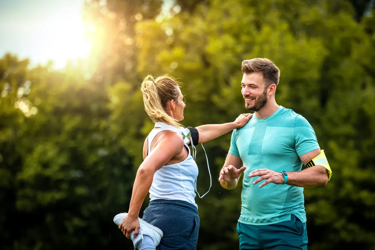 shot of a sporty young couple stretching together outdoors