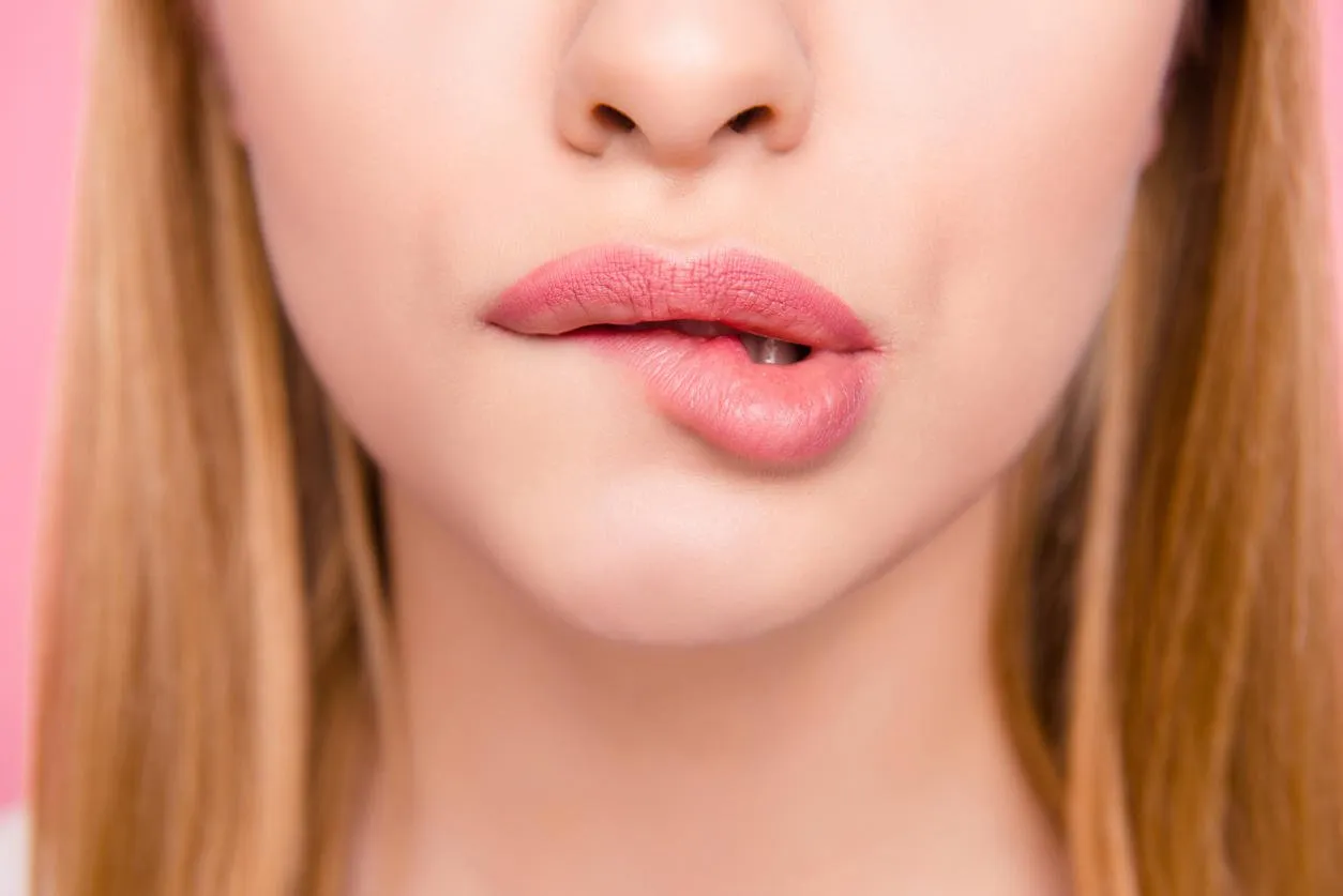 fillers plump plastic herpes surgery concept close up cropped photo of big full natural with lipgloss lips teeth biting lips blonde hair hairstyle isolated on background