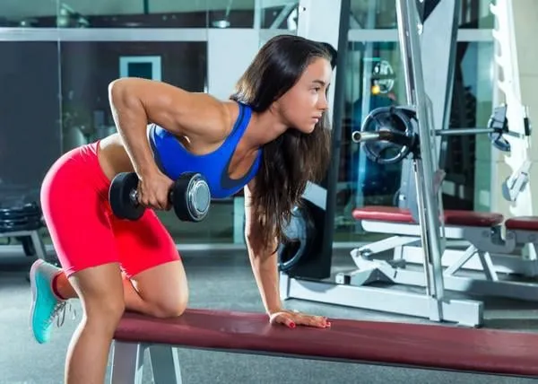 haltère triceps kickback fille exercice d'entraînement au gymnase