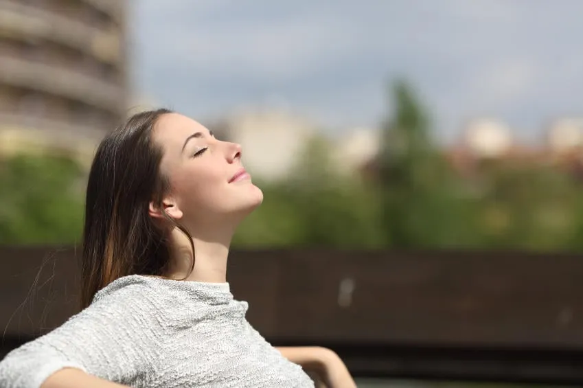 femme urbaine assis sur un banc d'un parc et respirer l'air frais