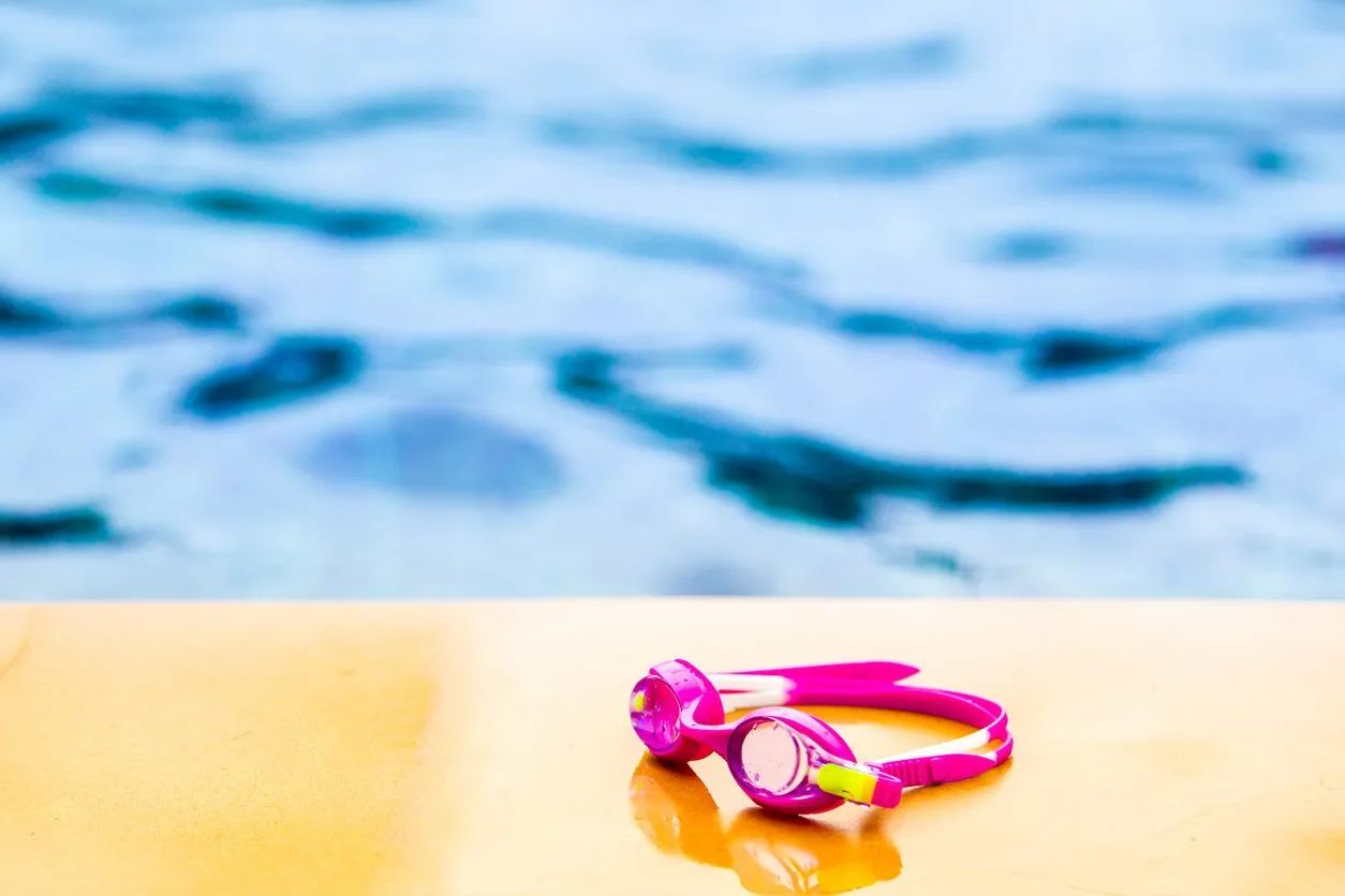 kids's swimming goggles left on the swimming pool edge close up