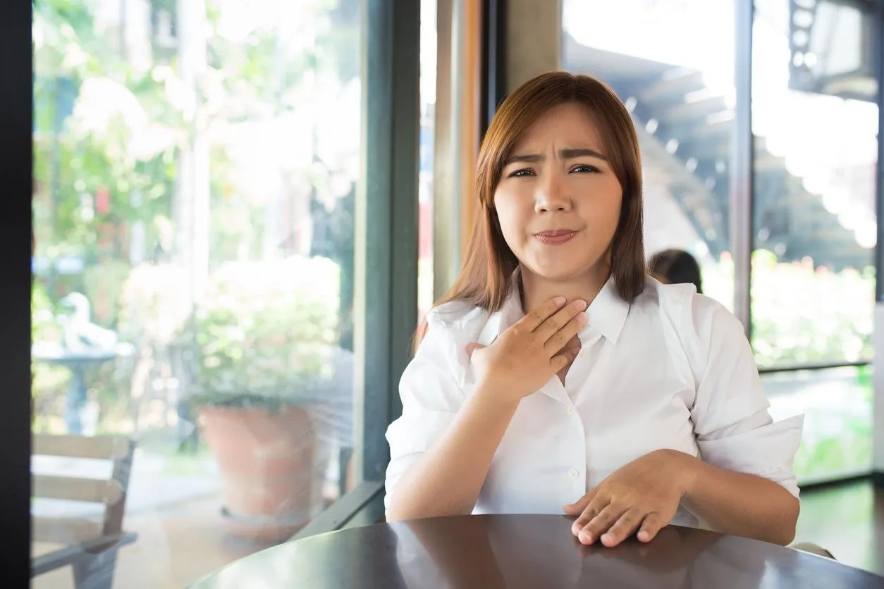 woman has sore throat at coffee shop