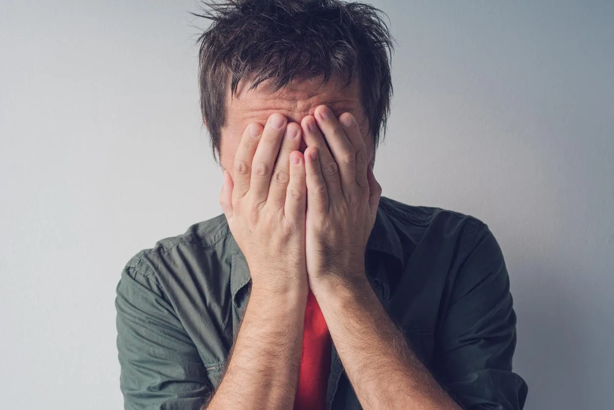 disappointed man crying with head in hands sad and lonely adult male hiding tears