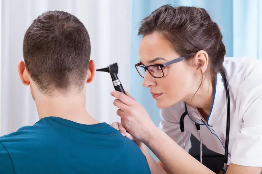 jeune femme médecin examinant l'oreille de son patient