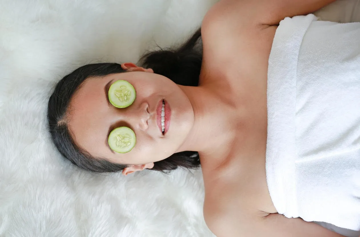 young woman with a slice of cucumber in her eye, concept for skin care
