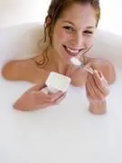 femme dans une baignoire, mangeant un yaourt