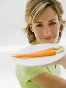 femme tenant une assiette avec deux carottes dessus