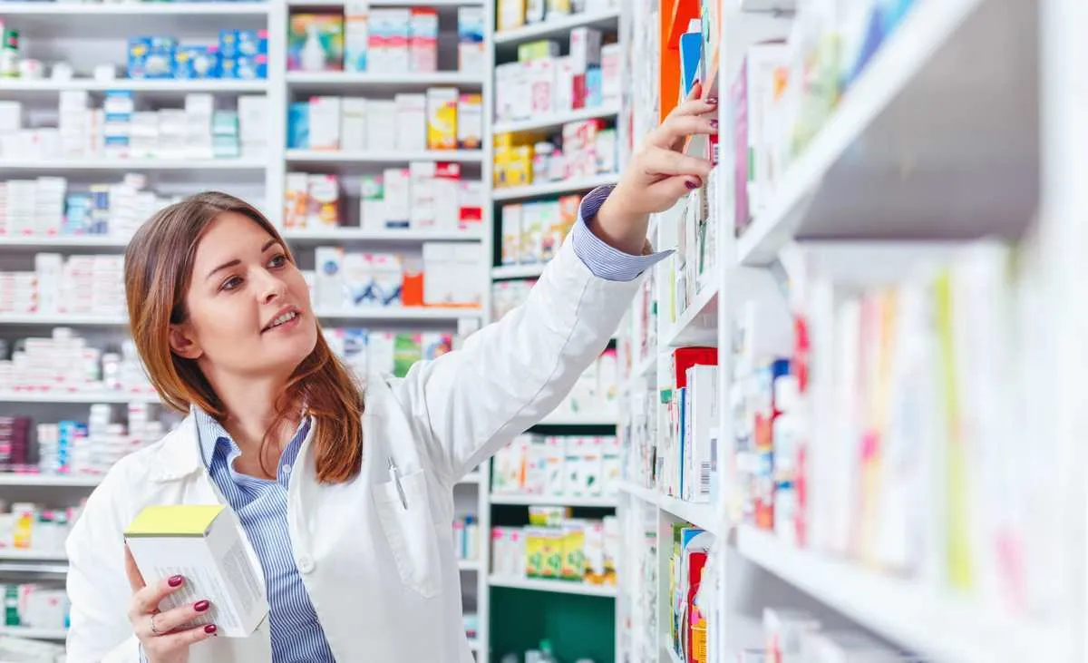 photo of a professional pharmacist checking stock in an aisle of a local drugstore