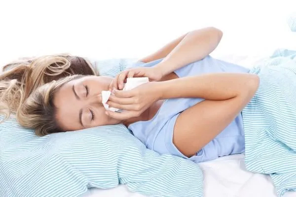 jeune femme avec un mouchoir au lit