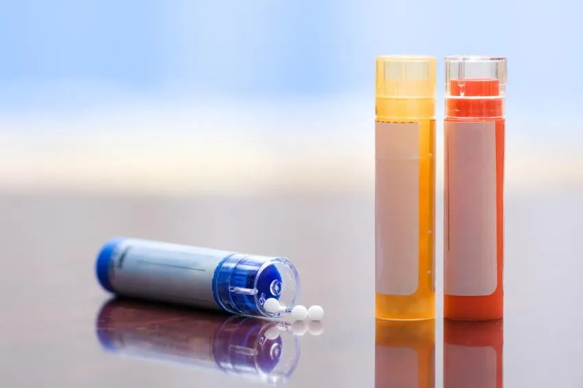 vue rapprochée des médicaments homéopathiques - récipients et petites boules blanches