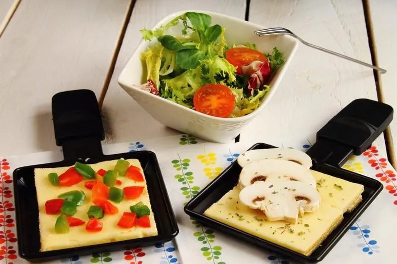 raclette con queso, verduras y ensalada