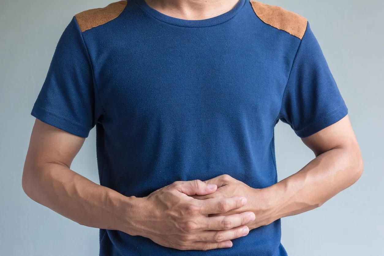 man have stomachache on gray background