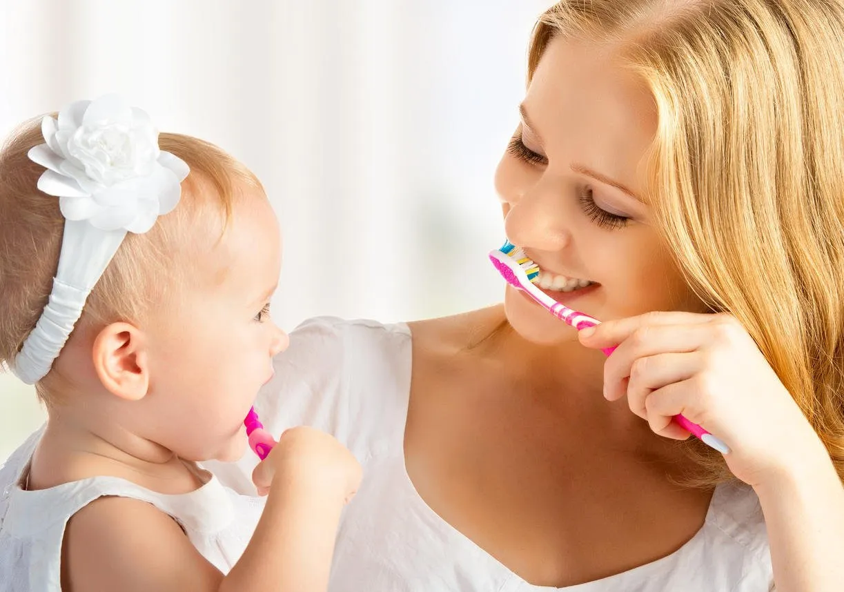 heureuse famille et santé mère et fille bébé fille se brosser les dents ensemble