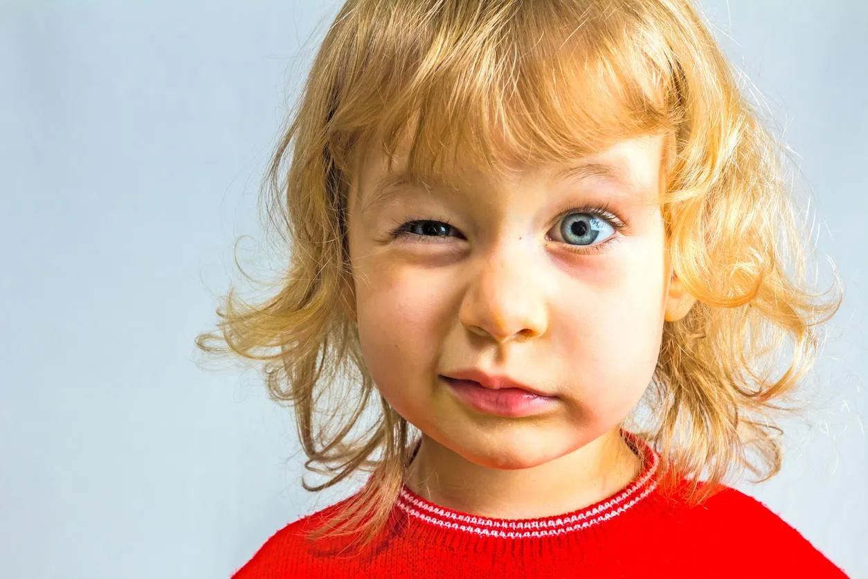 aux yeux bleus, fille de 3 ans en robe rouge