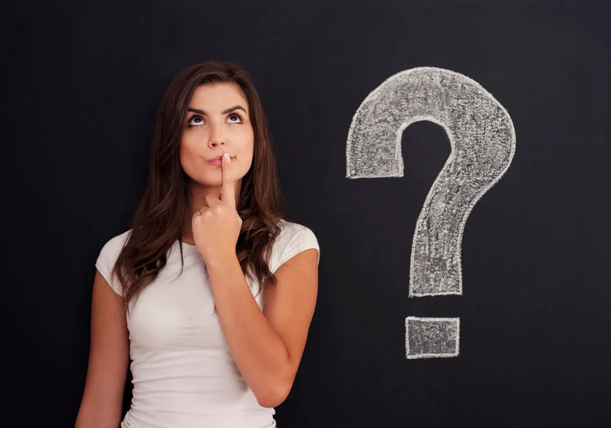 inquisitive woman next to question mark on blackboard