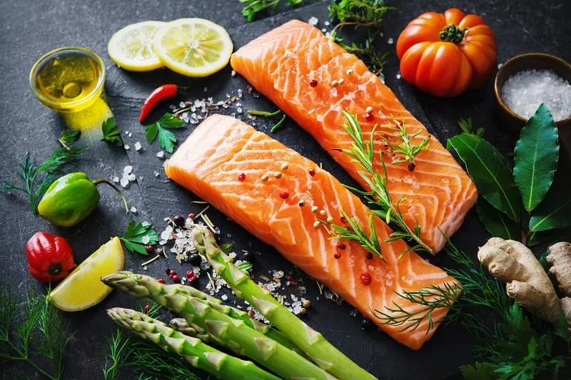 fresh salmon fillet with aromatic herbs, spices and vegetables balanced diet or cooking concept