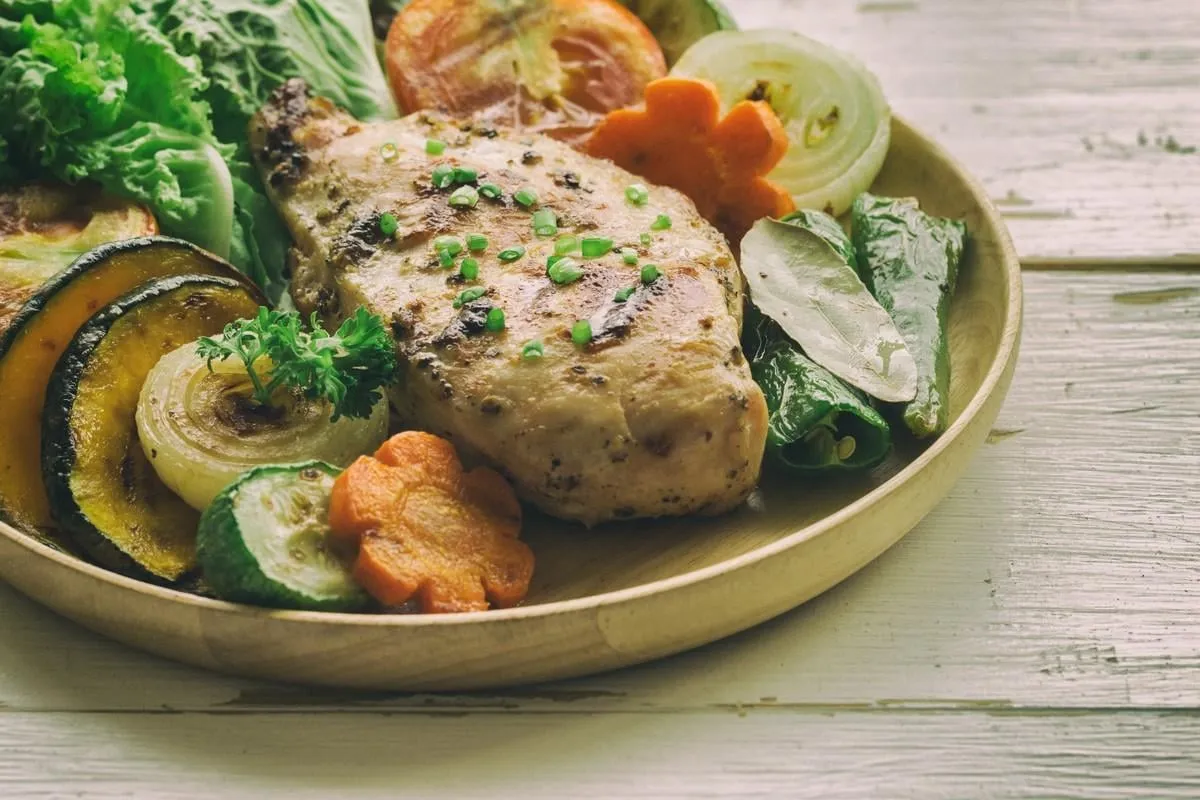 homemade chicken breast barbecue on wood plate served with grilled vegetables delicious chicken barbecue and grilled vegetables for lunch or dinner roast chicken breast on rustic wood table